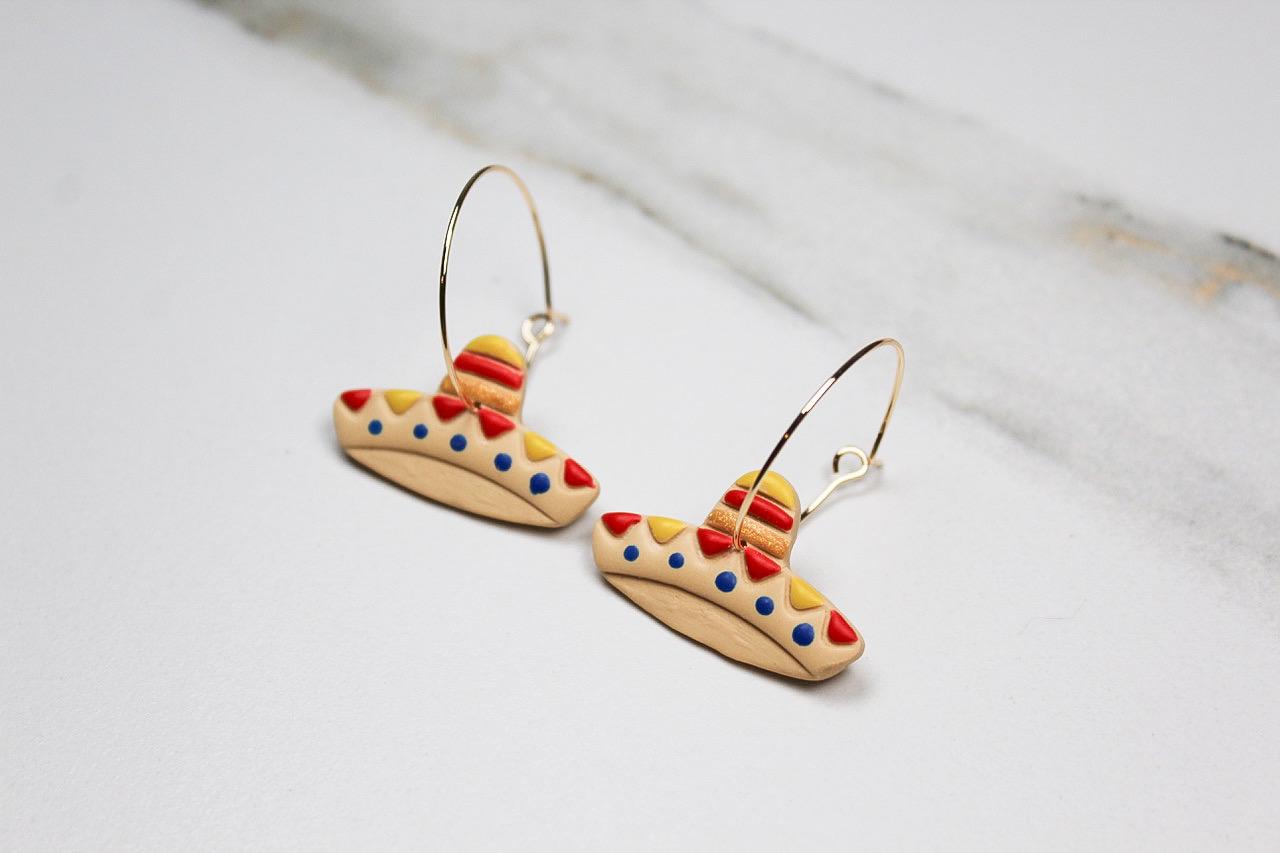 Pair of sombrero-shaped hoop earrings on a light background