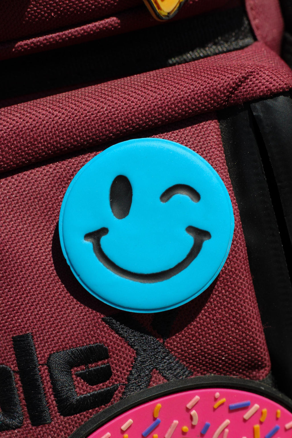 Blue smiley face pinon a red bag