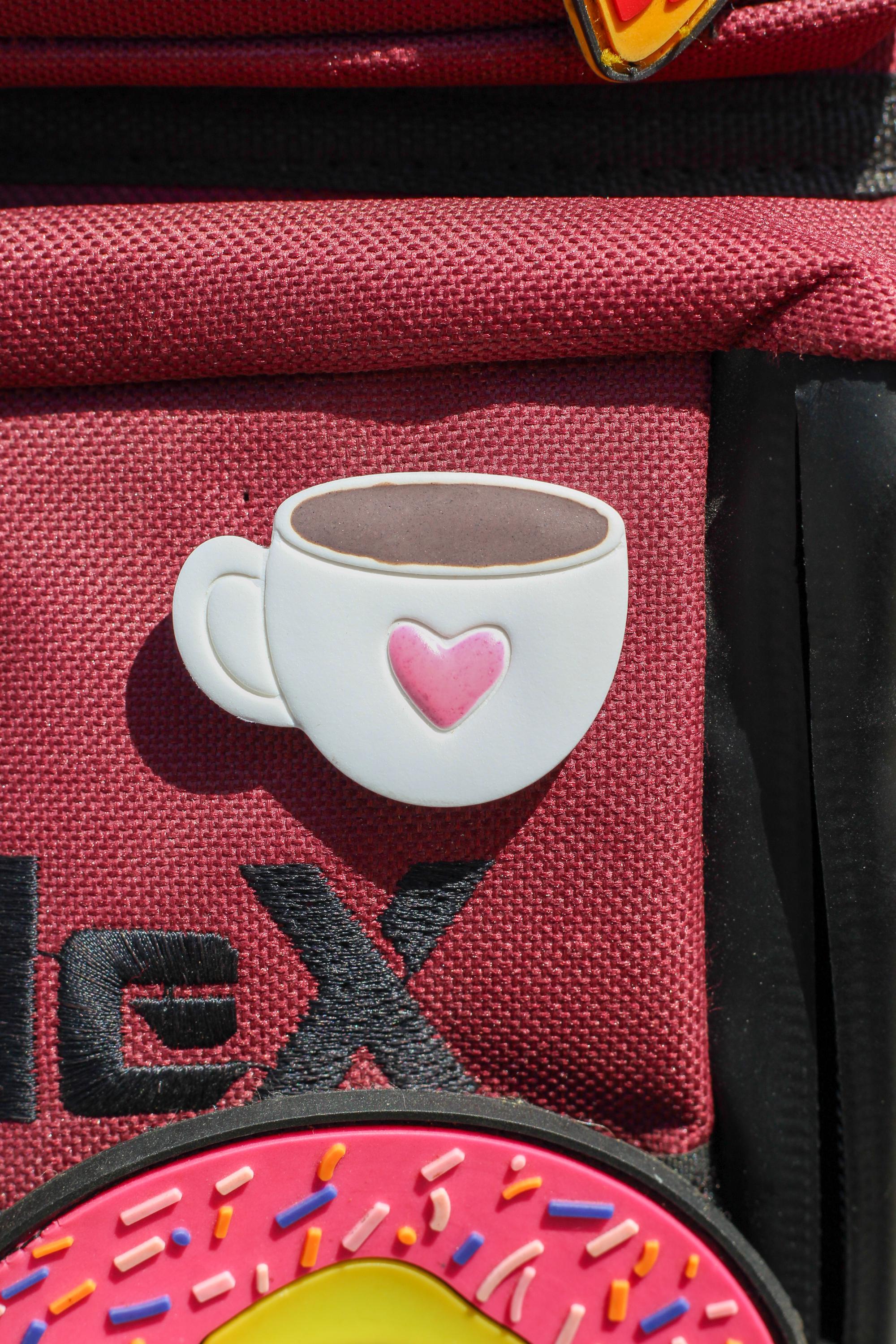 A  coffee cup pin on a red bag
