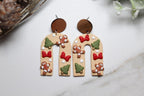 Wooden earrings shaped like an arch with decorative elements on a light surface.