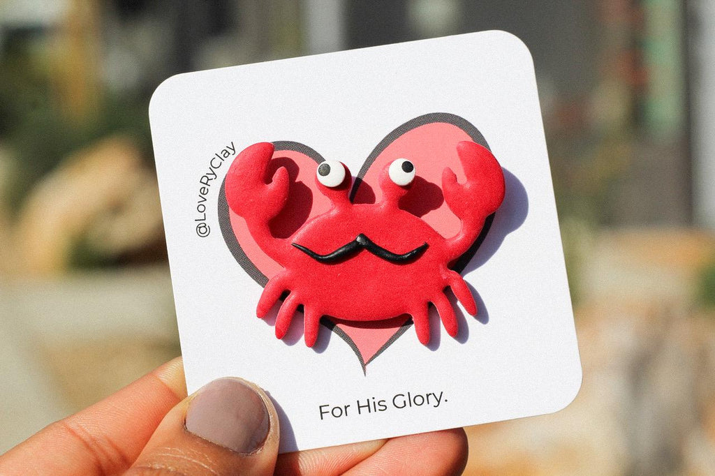 Card with a red crab design held by a hand.
