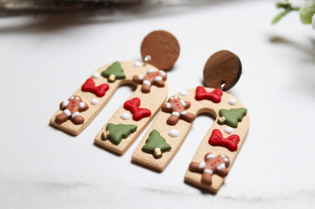 Gingerbread-themed earrings on a light background