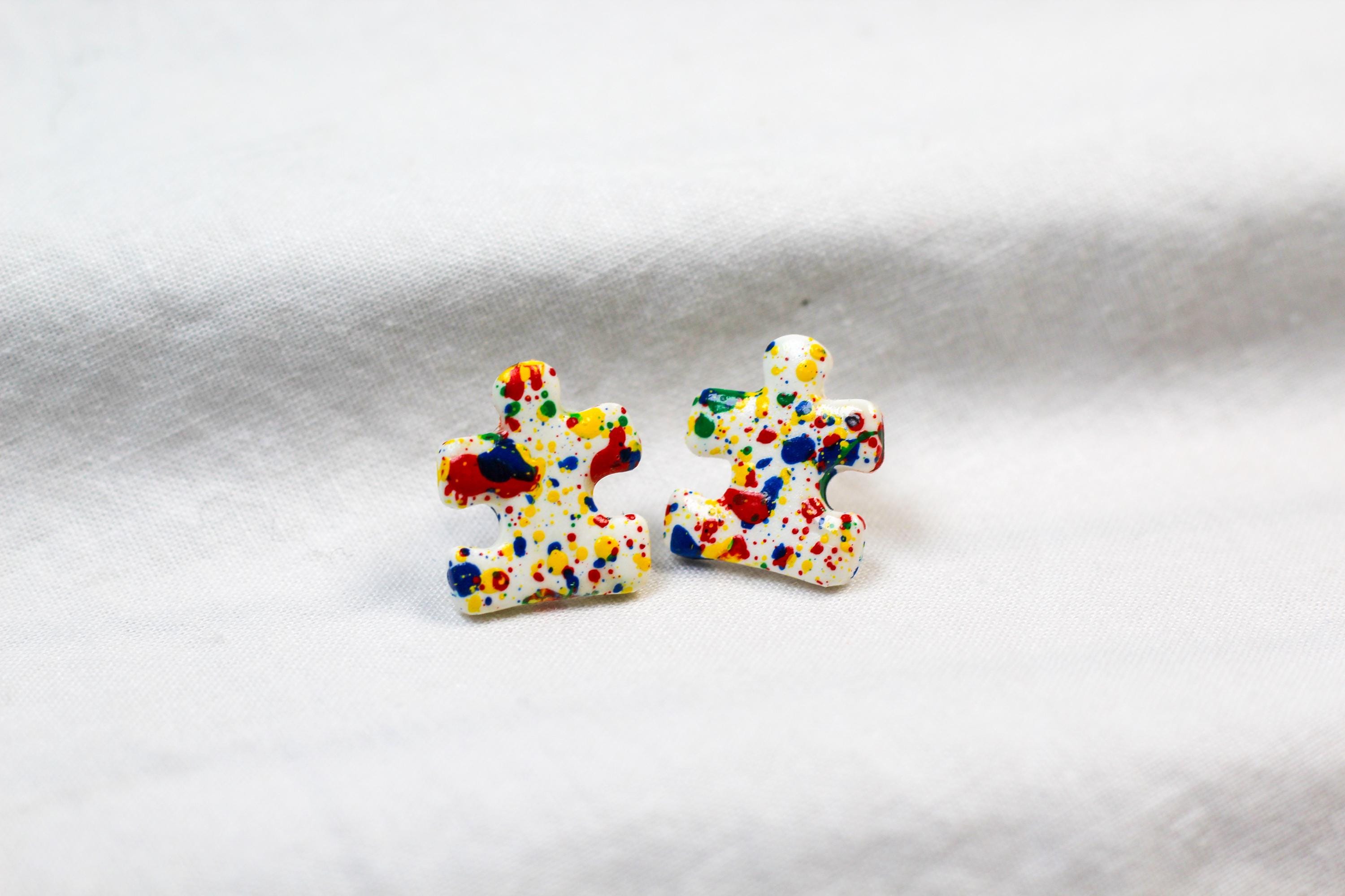 Colorful puzzle piece earrings on a white background