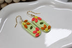 Colorful floral earrings on a white dish