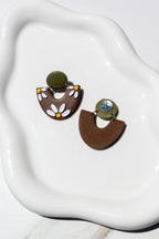 Pair of floral earrings on a white dish