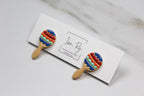 Colorful maraca-shaped earrings on a card with 'Love, Ry' branding.
