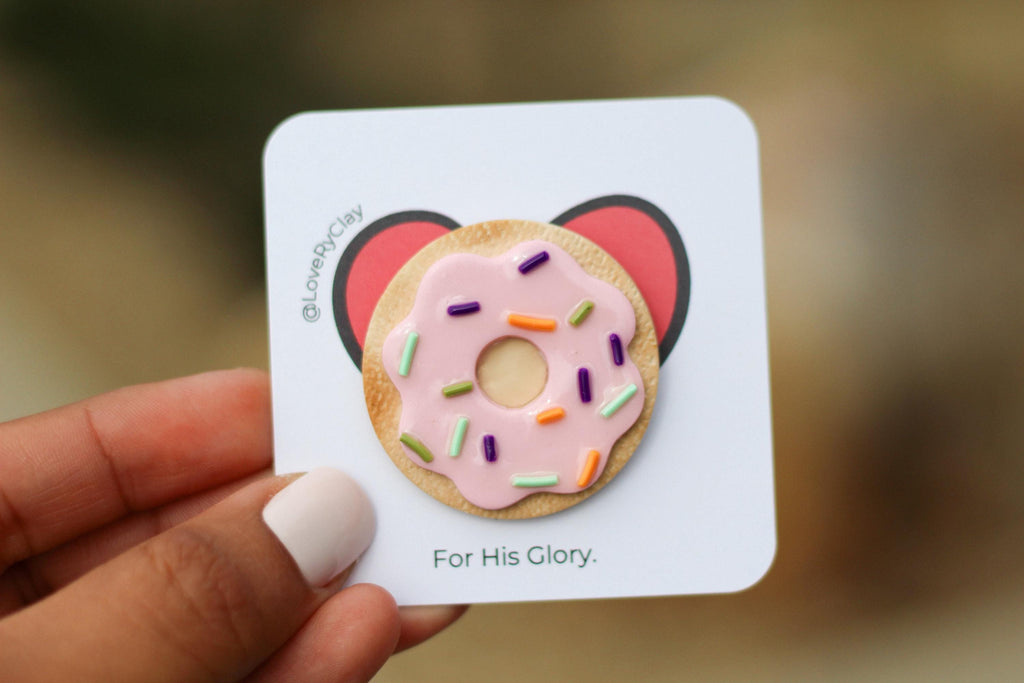 Card with a donut design and 'For His Glory' text held by a hand.