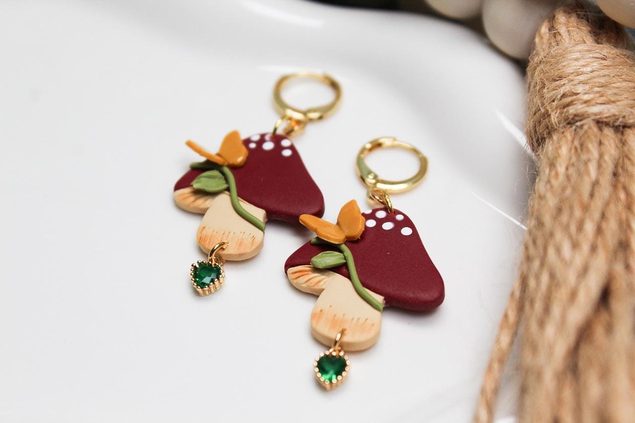 Mushroom-shaped earrings with colorful details on a white surface