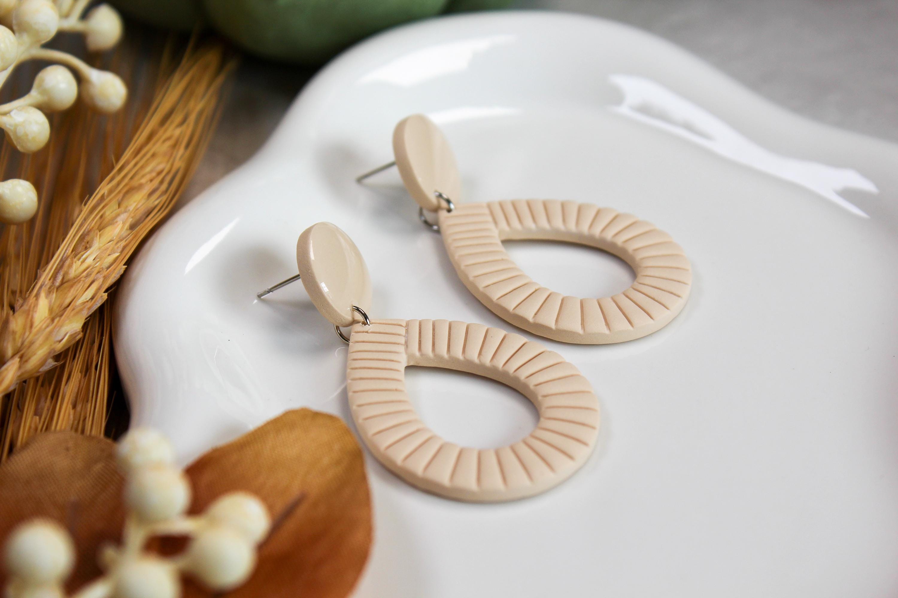 Ivory earrings on a white dish with decorative elements.