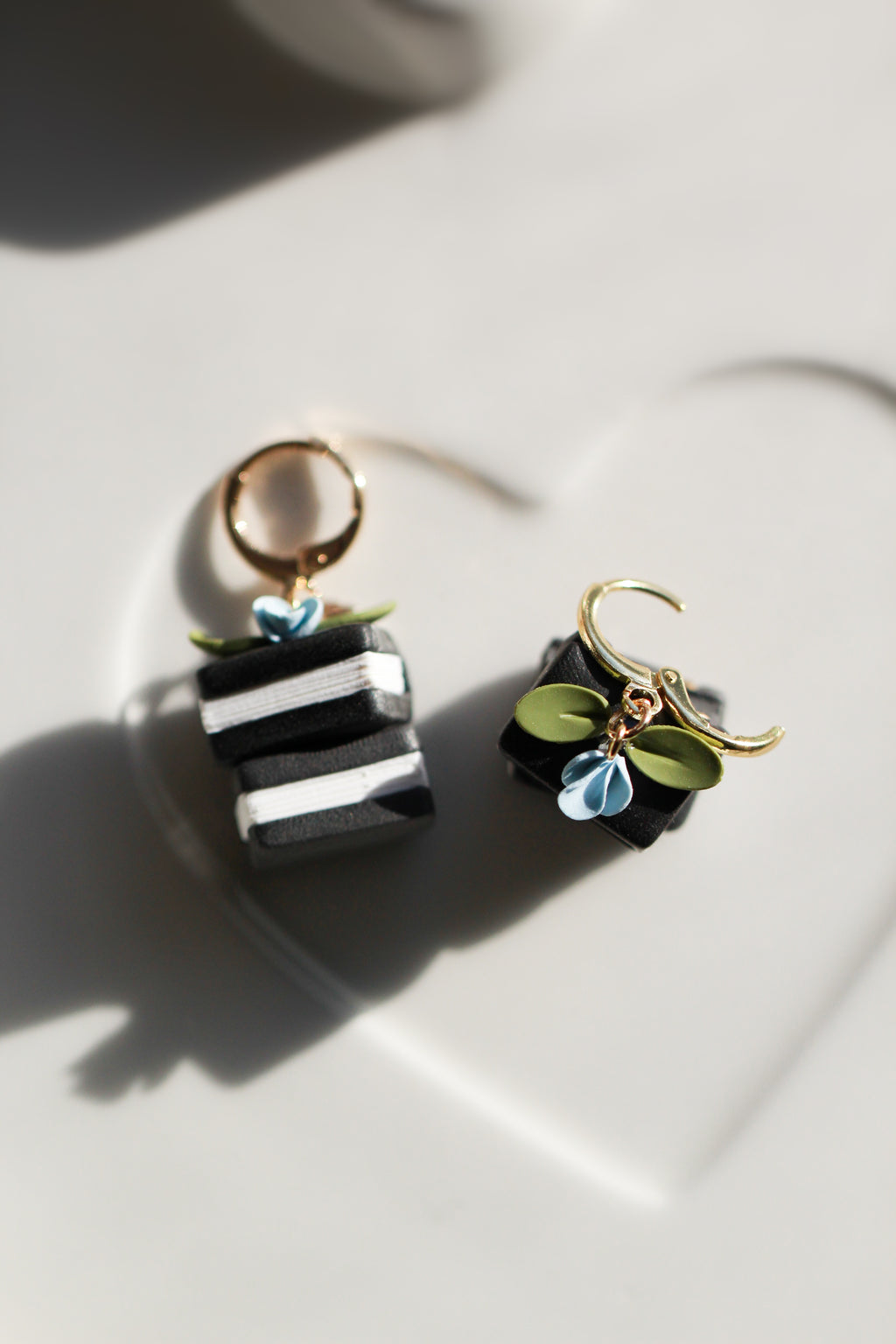 Pair of earrings with black and white book  on a light background