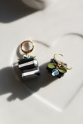 Pair of earrings with black and white book  on a light background