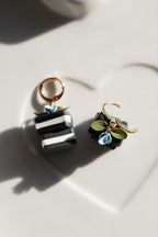 Pair of earrings with black and white book  on a light background