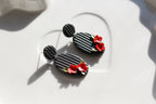 Black earrings with red floral details on a white surface