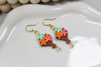 Colorful flower-shaped bouquet earrings on a white dish