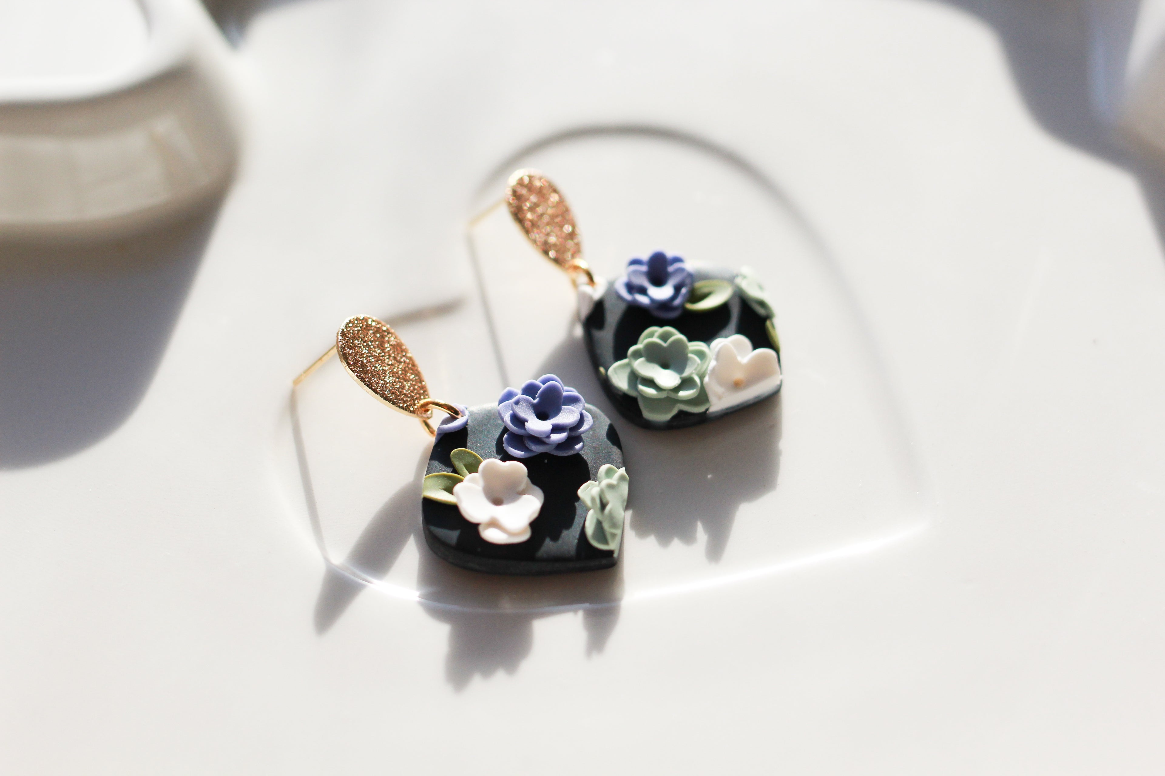 Pair of floral earrings on a white surface