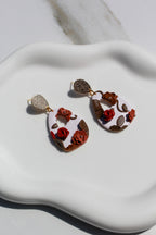Pair of earrings with floral design on a white surface