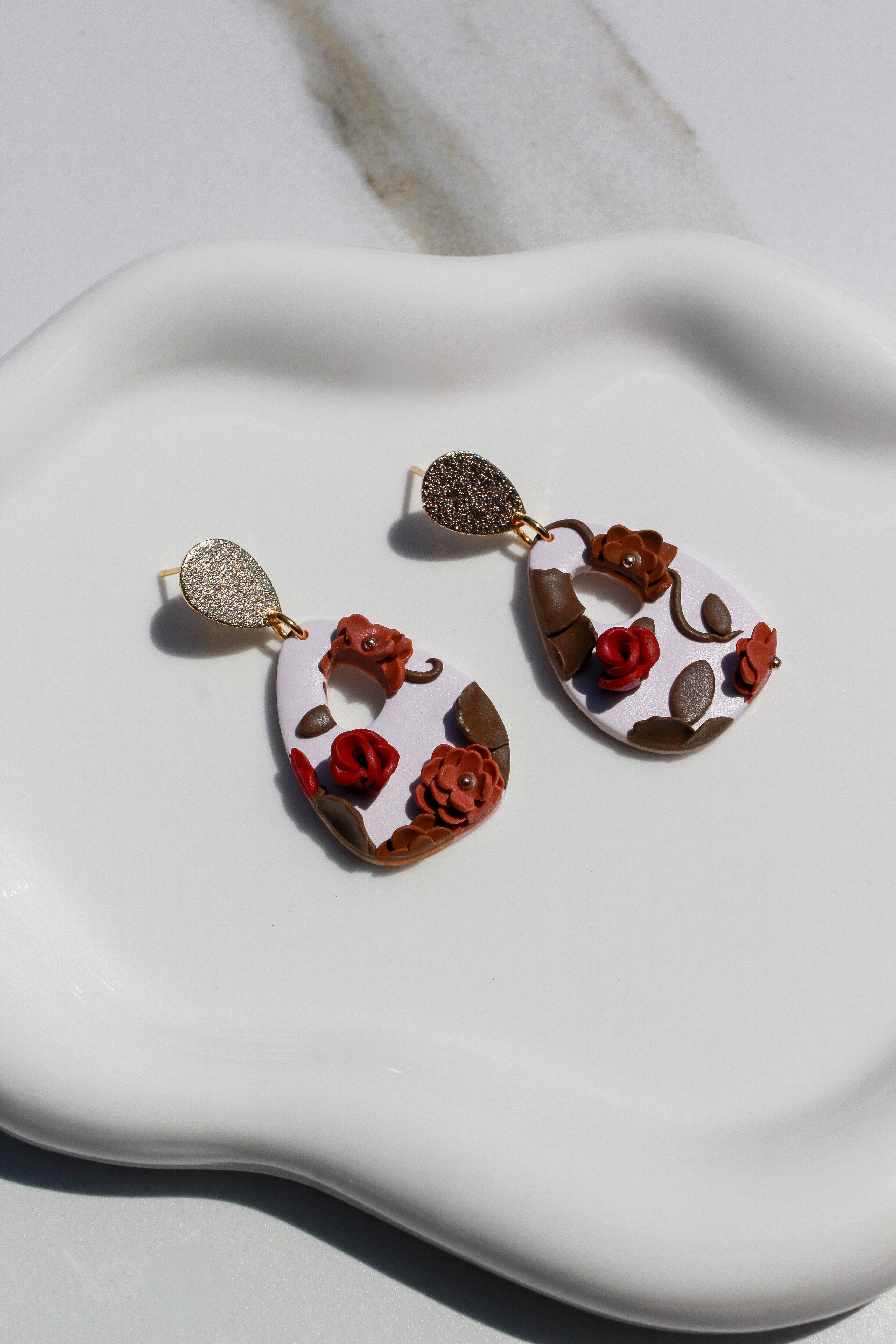 Pair of earrings with floral design on a white surface