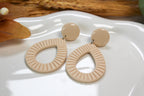 Ivory earrings on a white plate with a natural background
