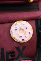 Donut-shaped design with colorful sprinkles on a red bag