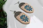 Pair of earrings with blue floral design on a white surface
