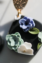 Close-up of a black pendant with floral designs on a reflective surface