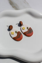Dessert style earrings on a white dish