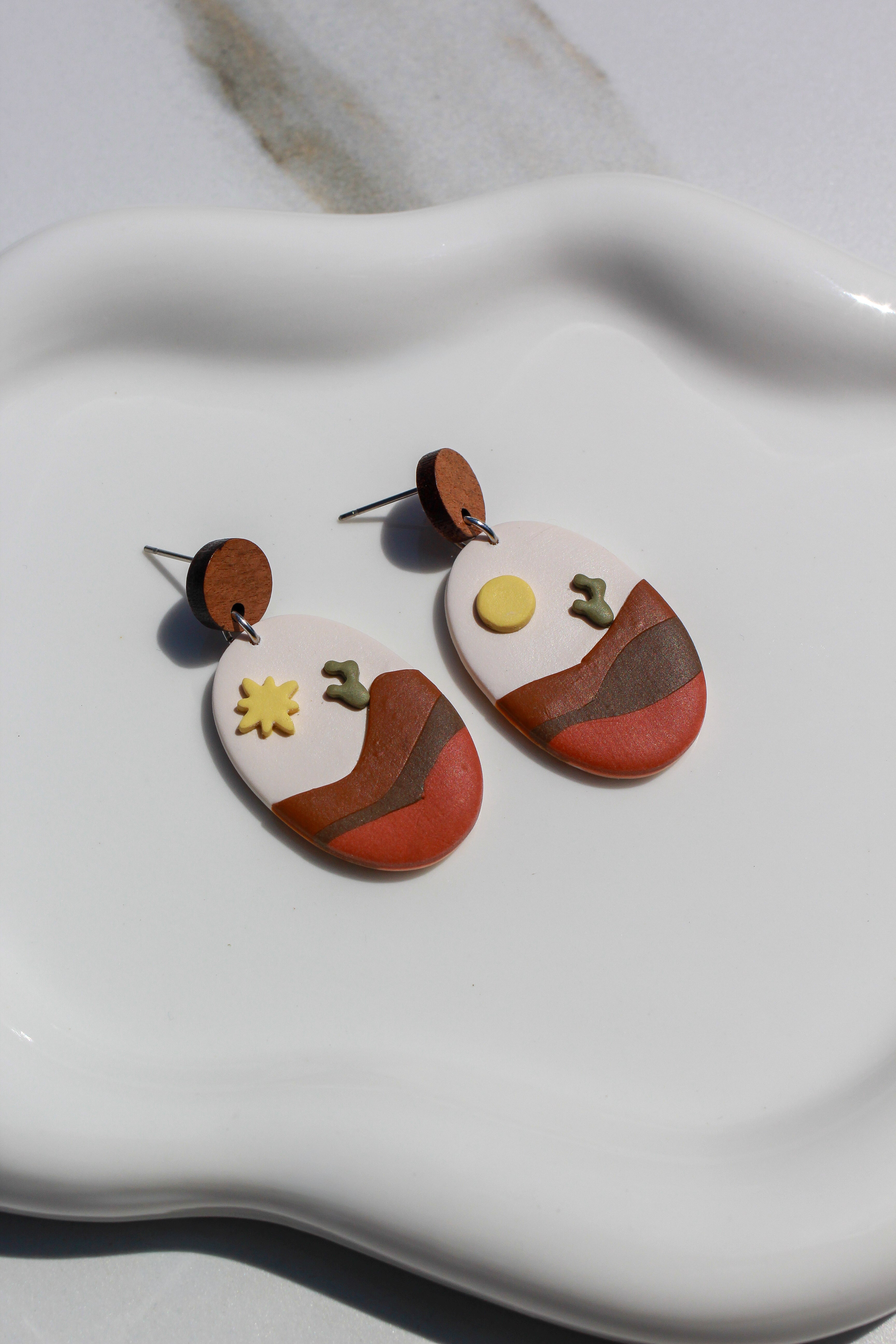 Dessert style earrings on a white dish
