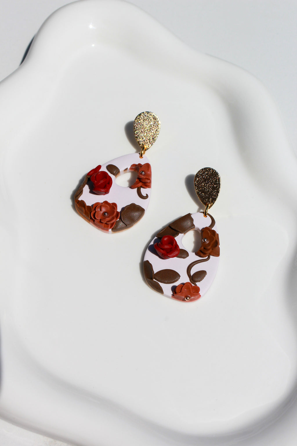 Floral earrings on a white stand