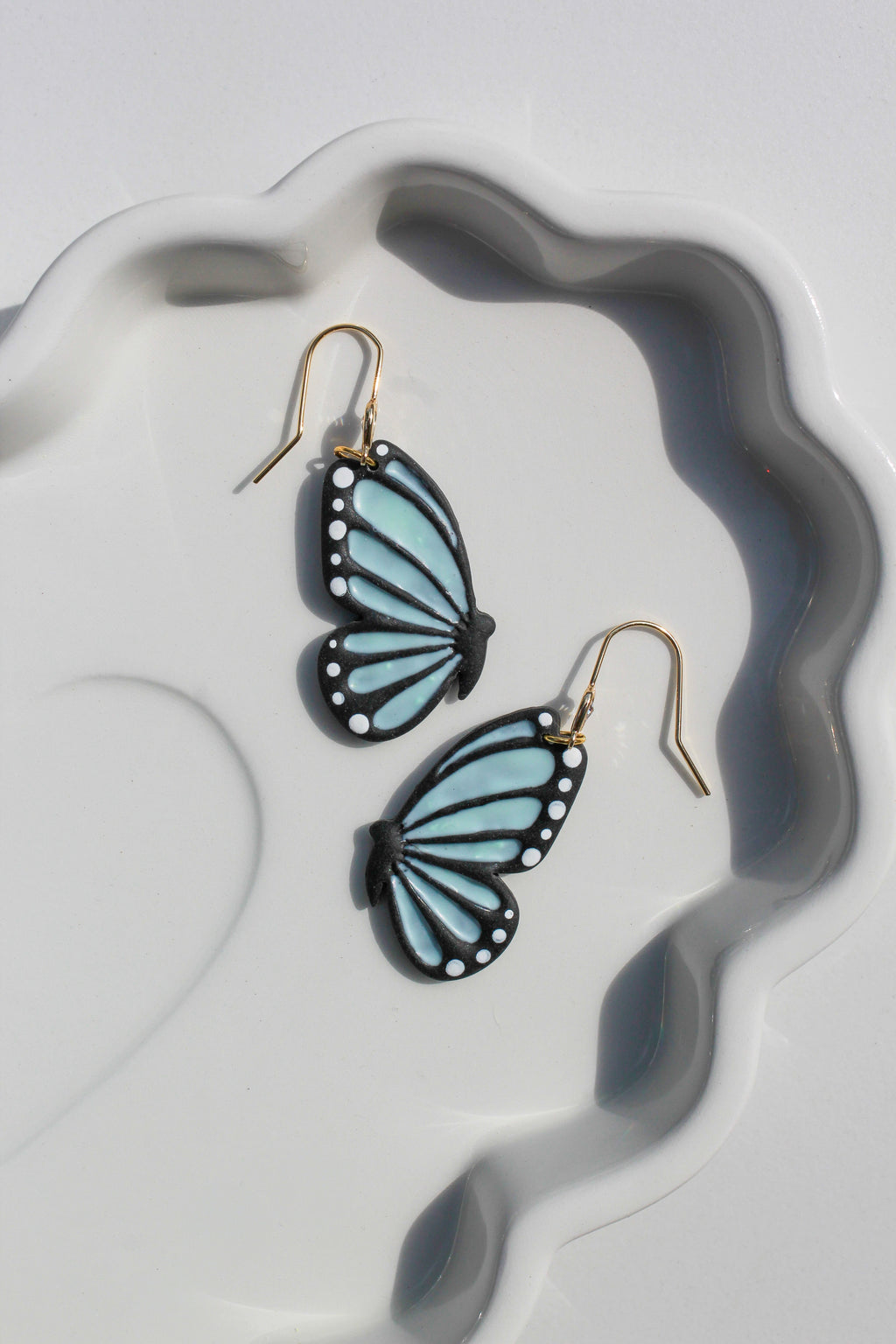 Butterfly-shaped earrings on a white dish