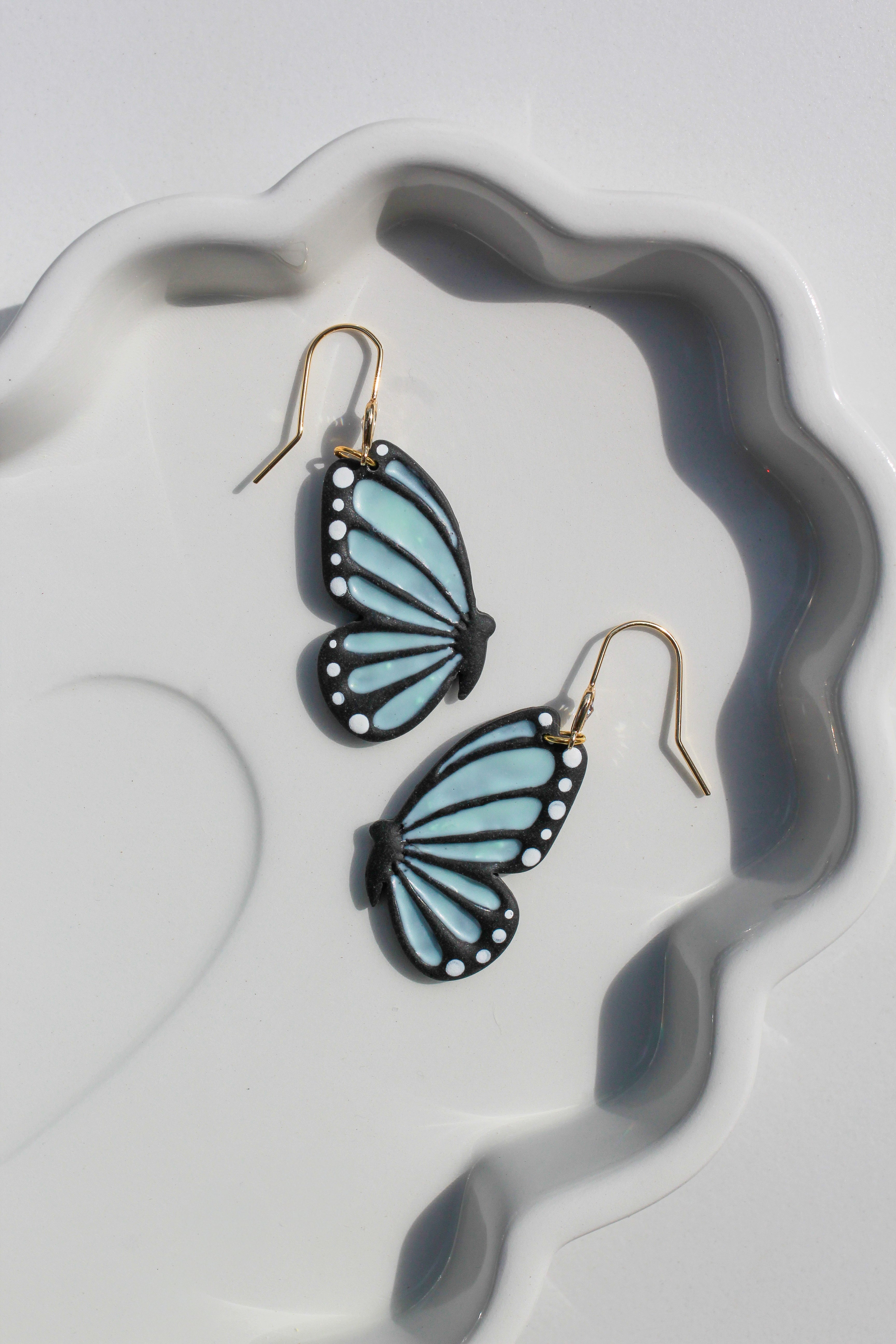 Butterfly-shaped earrings on a white dish