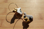 Pair of cow-shaped hoop earrings on a wooden surface