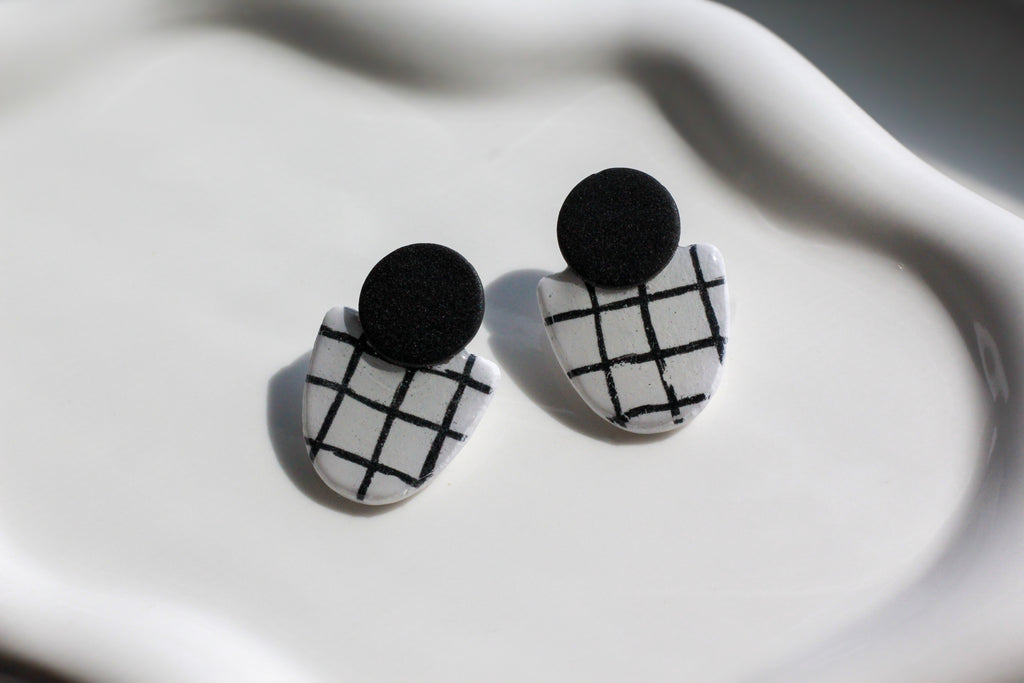 Black and white checkered earrings on a white surface