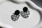 Black and white checkered earrings on a white surface