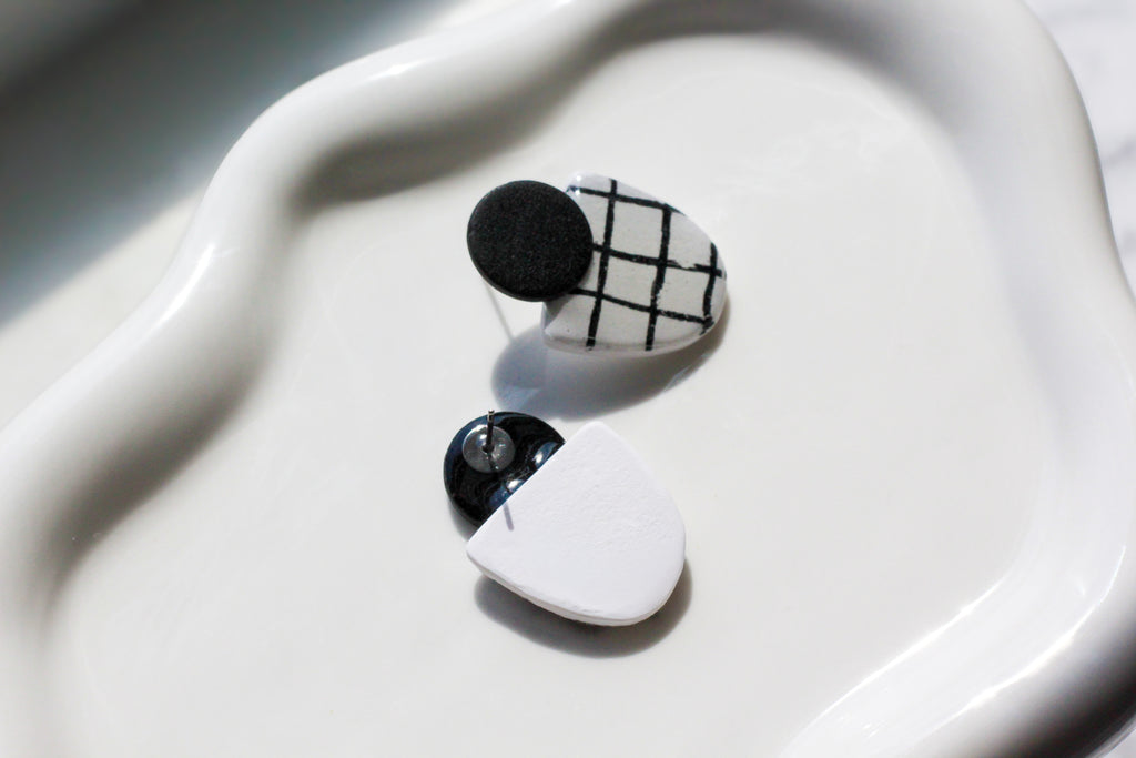 Black and white geometric earrings on a white dish