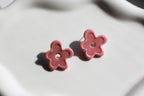 Pink flower-shaped earrings on a light background