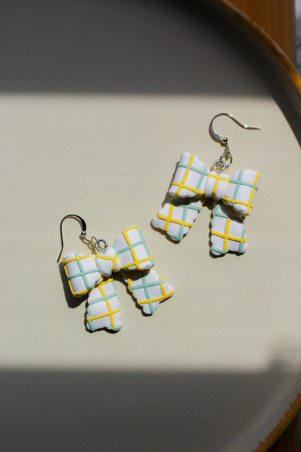 Pair of checkered earring bows on a light background