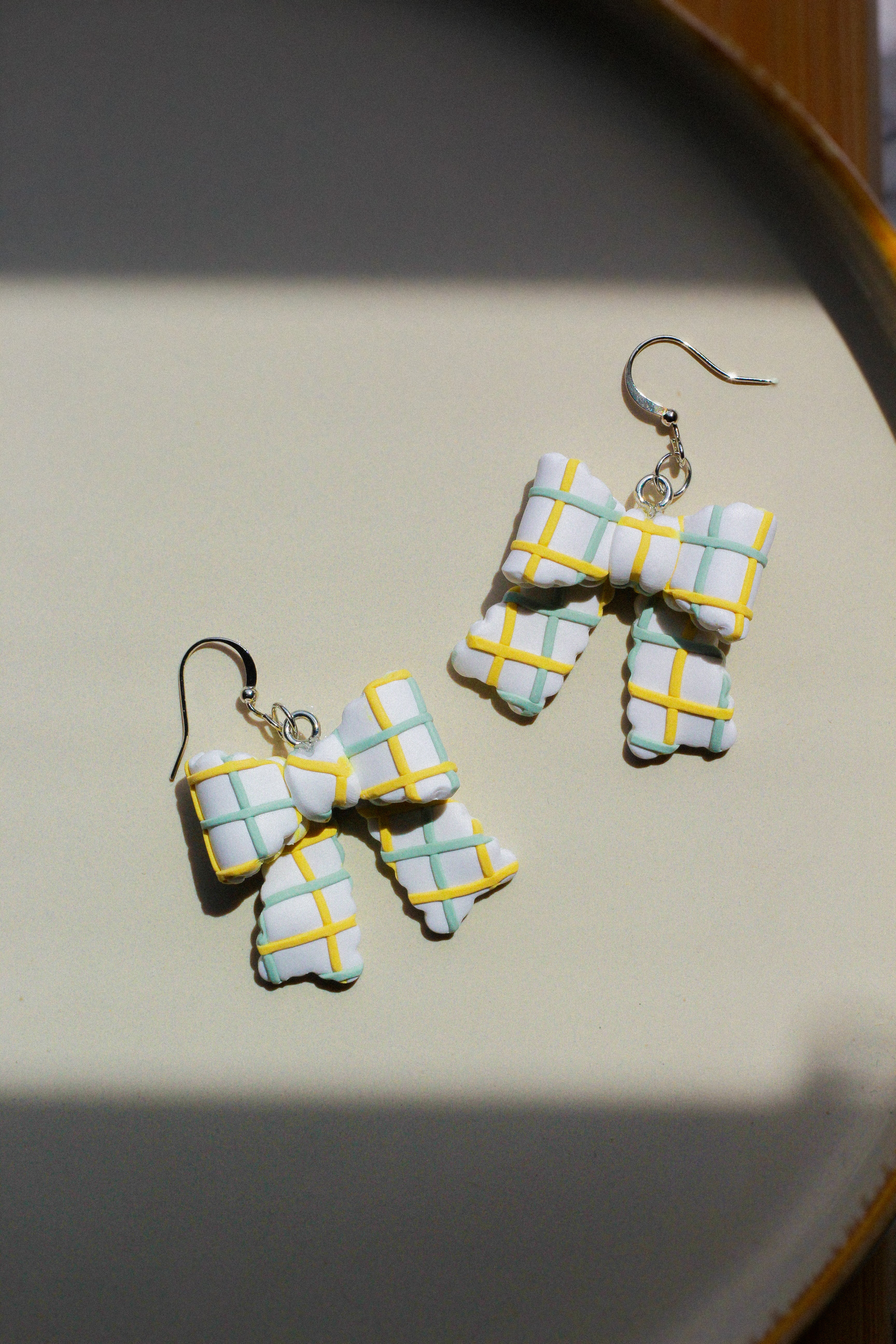 Pair of checkered earring bows on a light background
