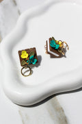 Pair of book earrings with floral design on a white surface