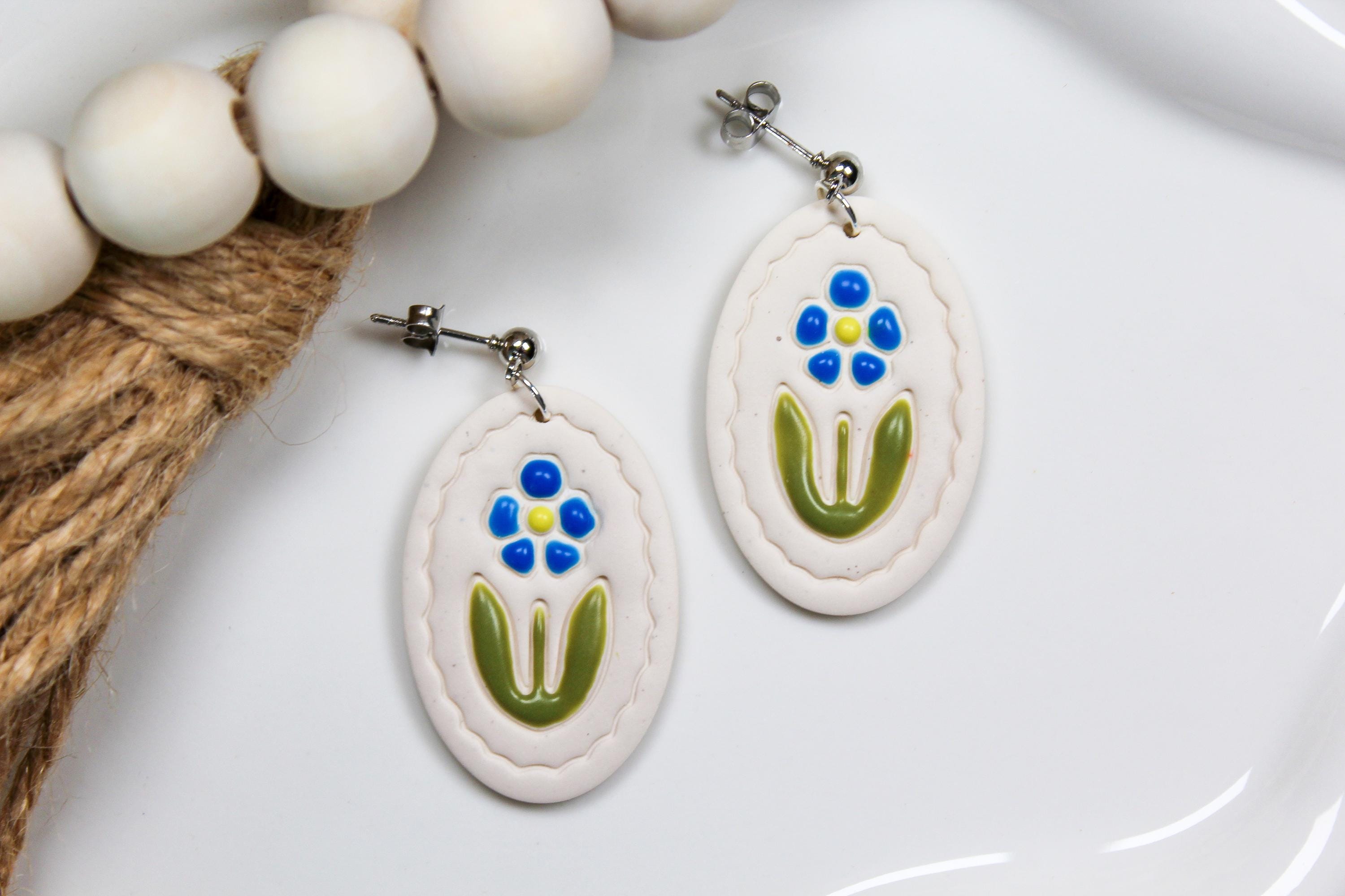 Pair of earrings with floral design on a white surface