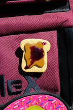 Pin of a toast on a red bag